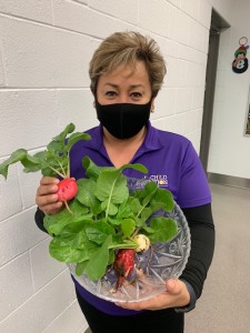 Cafeteria worker holds up radishes