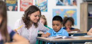 A Teacher watching a student show her a item on a page